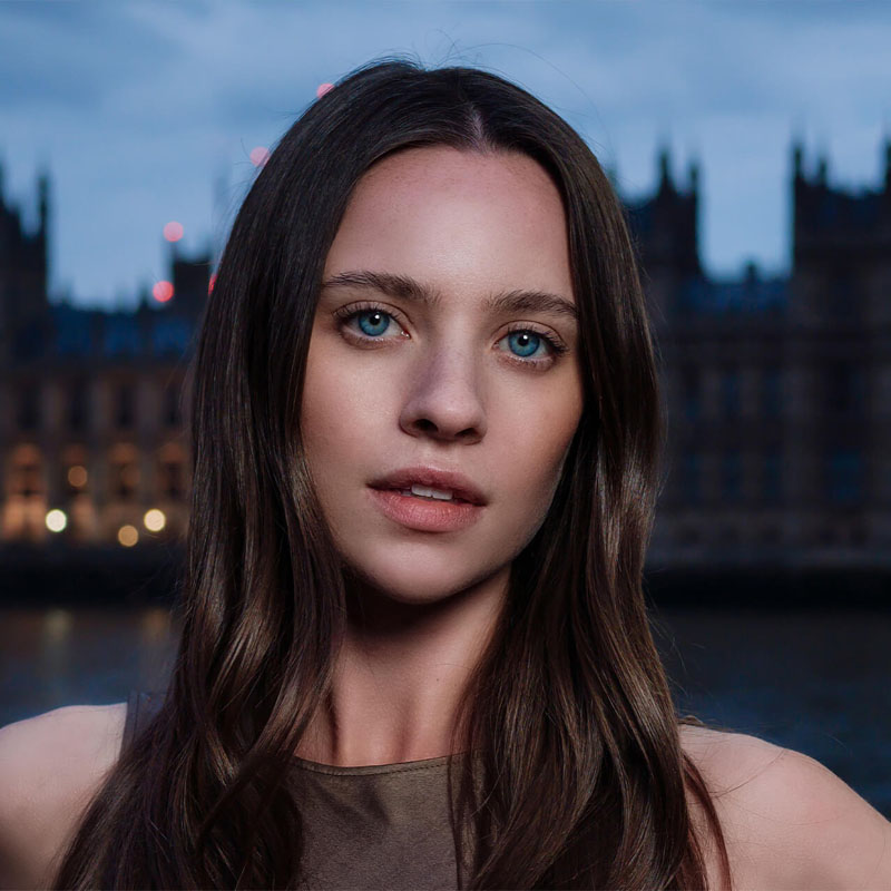 Portrait réalisé avec la DJI Osmo Pocket 4P devant un paysage urbain au crépuscule, mettant en valeur la netteté du sujet, le flou d'arrière-plan (bokeh) et les performances en basse lumière.