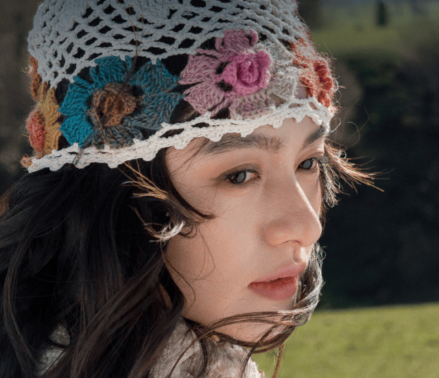 Portrait rapproché d'une femme portant un bonnet en crochet coloré, illustrant la netteté des détails de la caméra